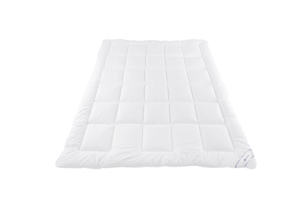 Biała kołdra Medical®+ KM 01, pikowana w trapezy z widocznymi metkami w rogu