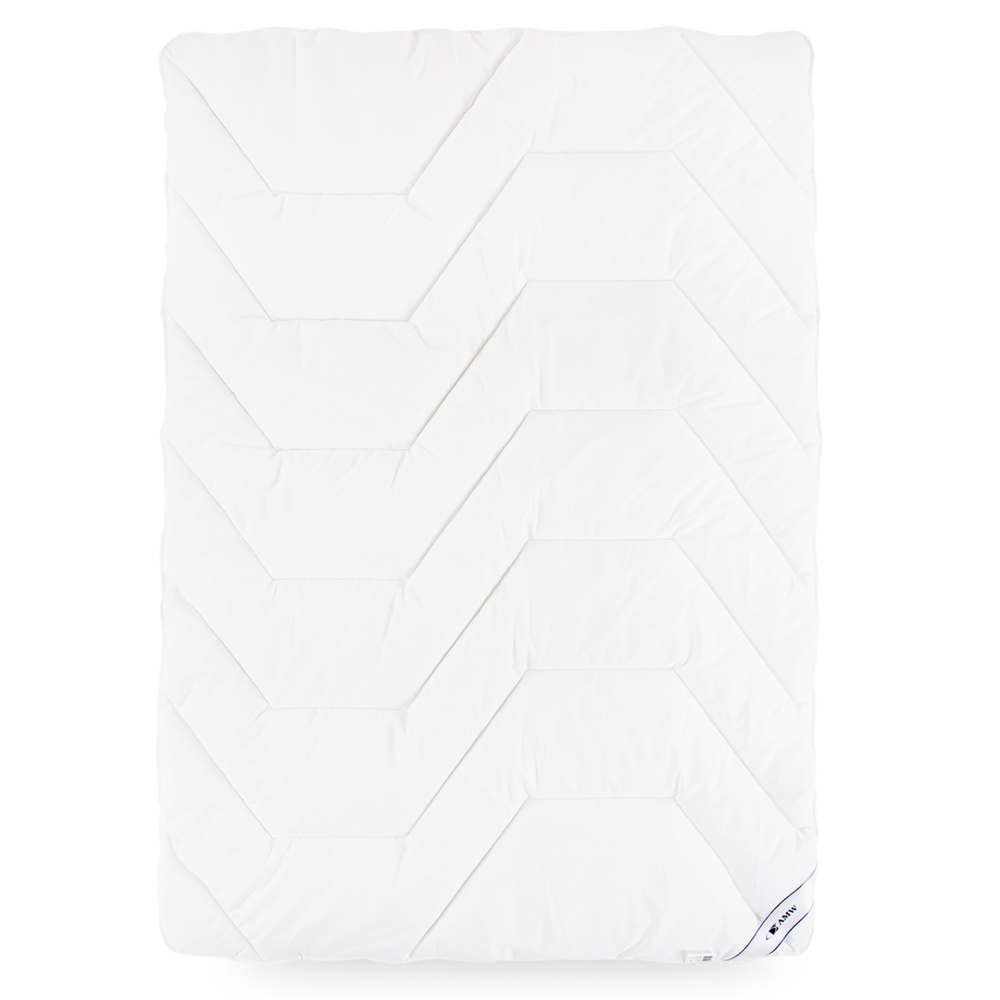 Biała kołdra Medical®+ KM 02, pikowana w trapezy z widocznymi metkami w rogu